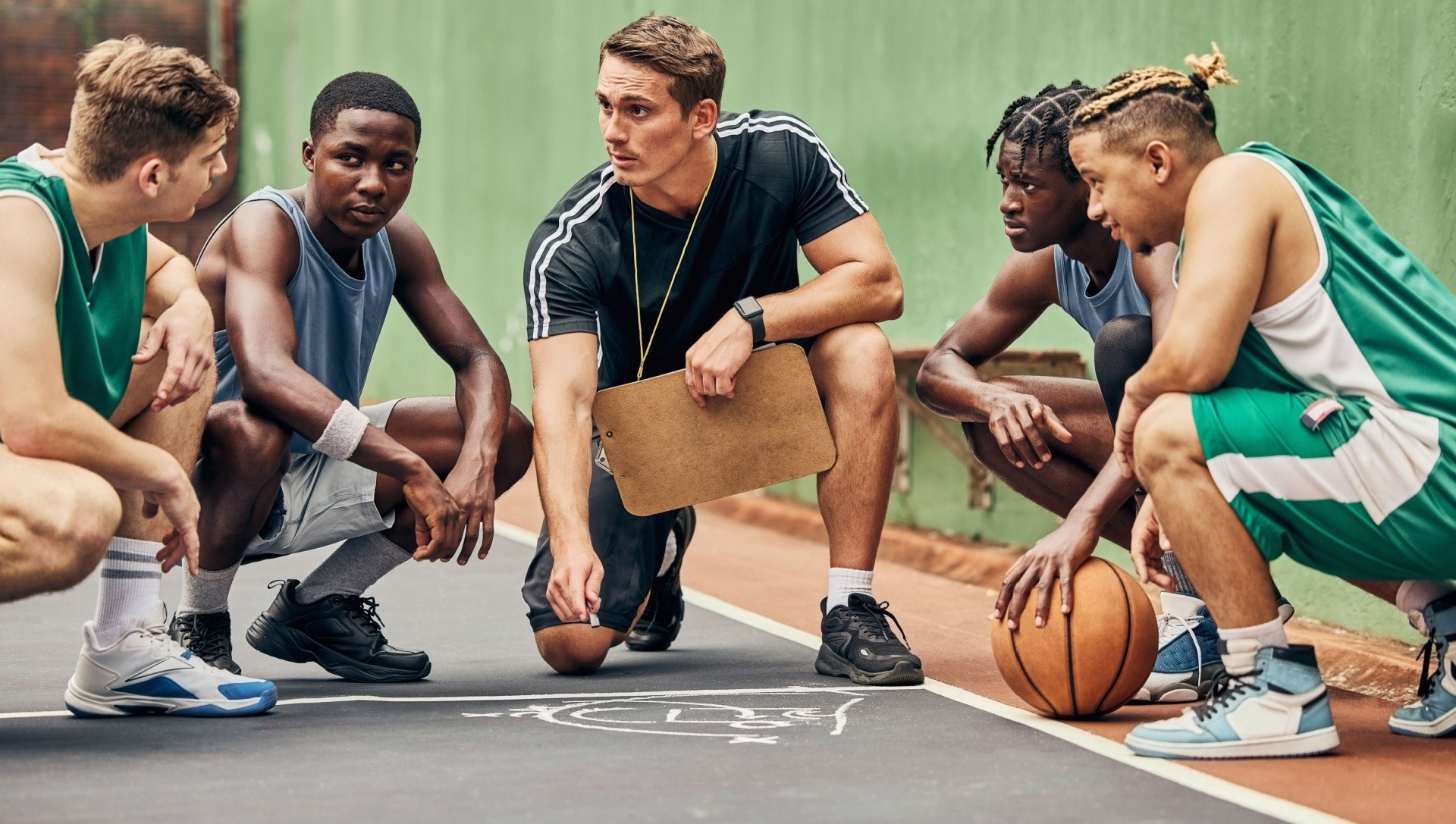Man in a huddle with his team of children leading and coaching them