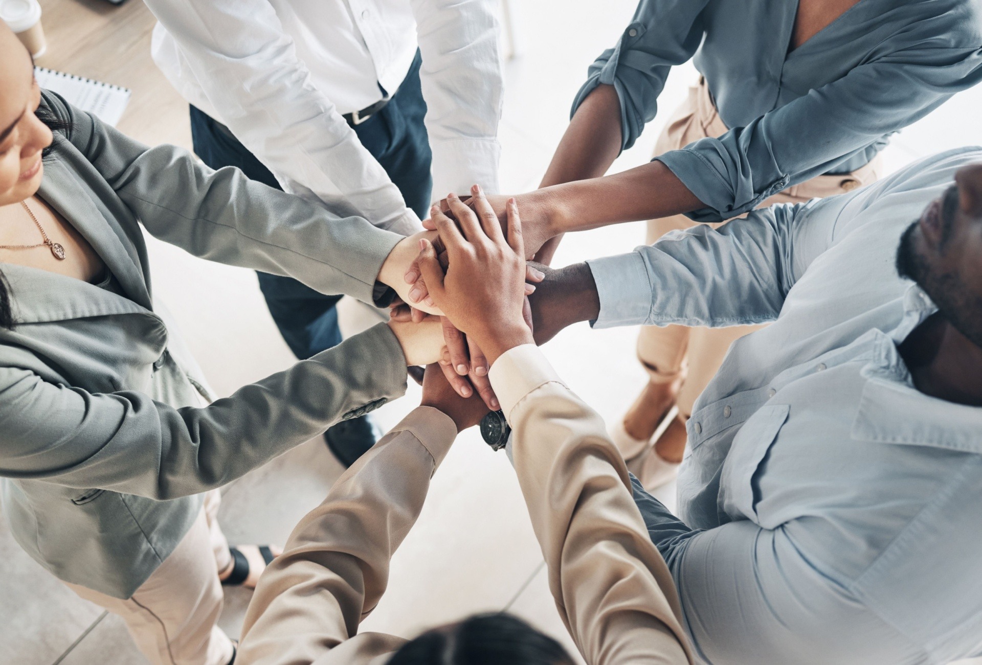 group of people with hands in to signify unity