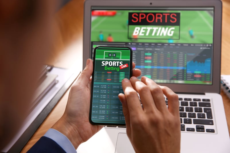 Image of man arbitrage betting on his iphone