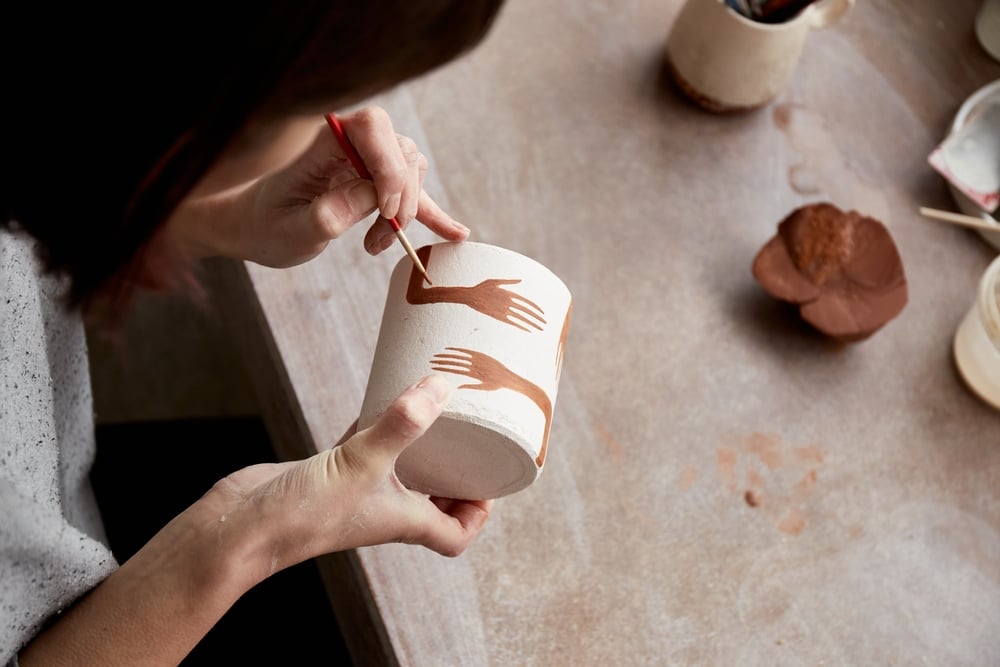 Woman painting a handmade mug