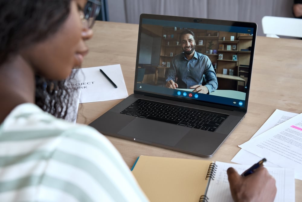Woman being tutored by a man on laptop