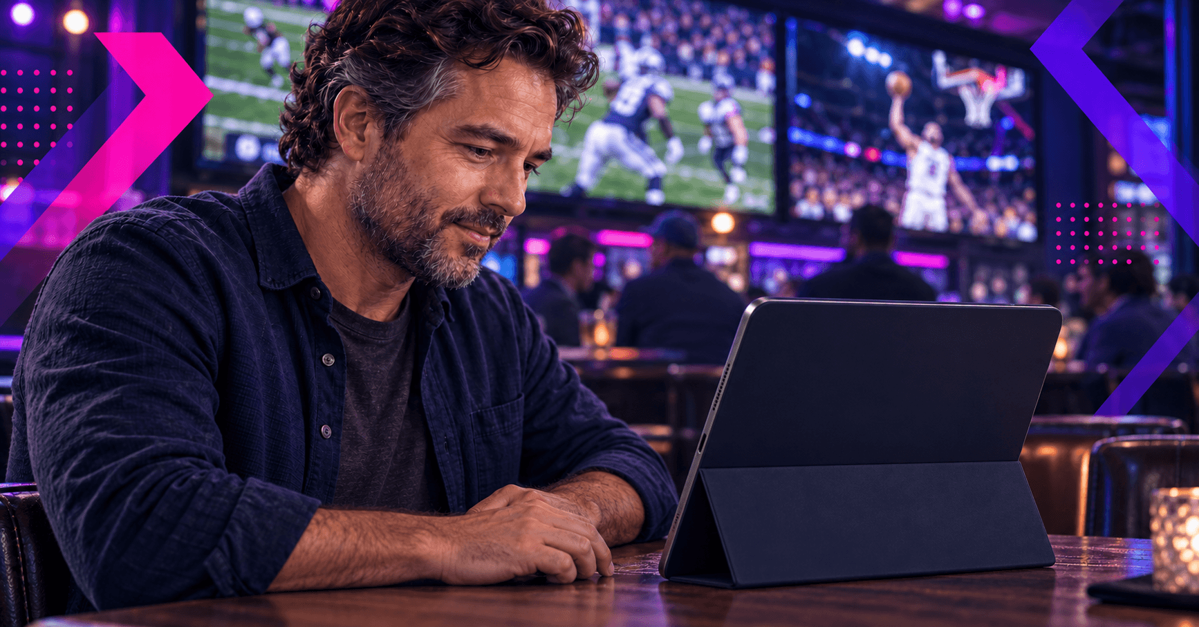 male in sports bar using a matched betting calculator on a tablet