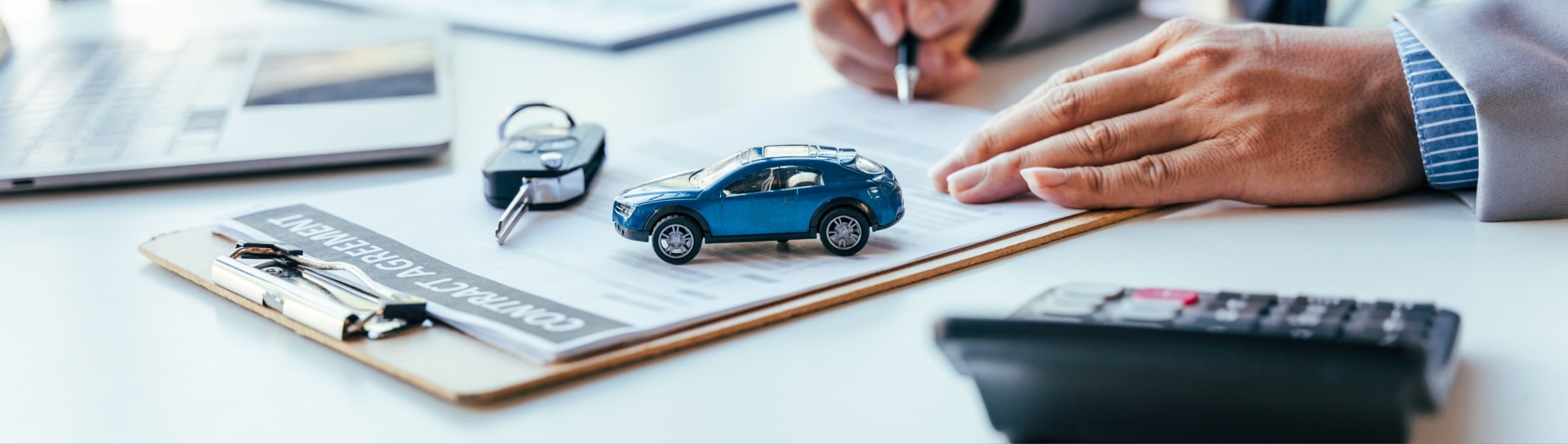 toy car on paper on top of a desk with a set of real life car keys next to it