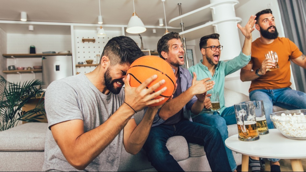 group of four friends watching basketball
