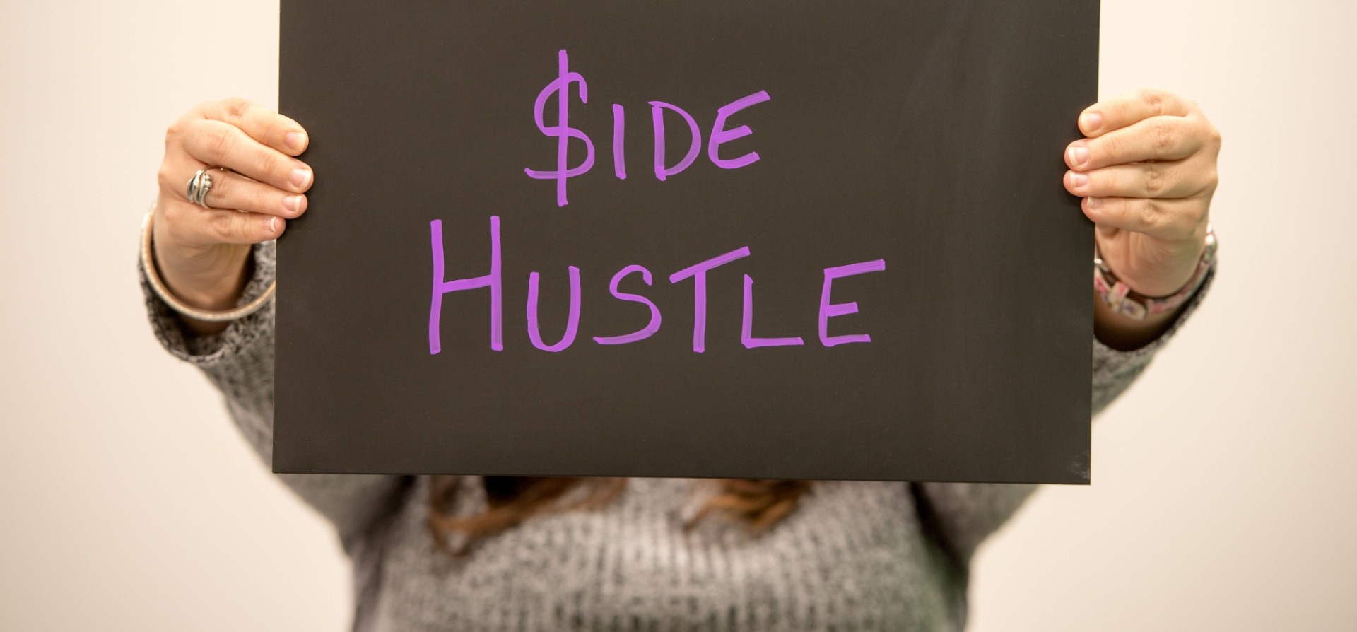 woman holding side hustle sign 