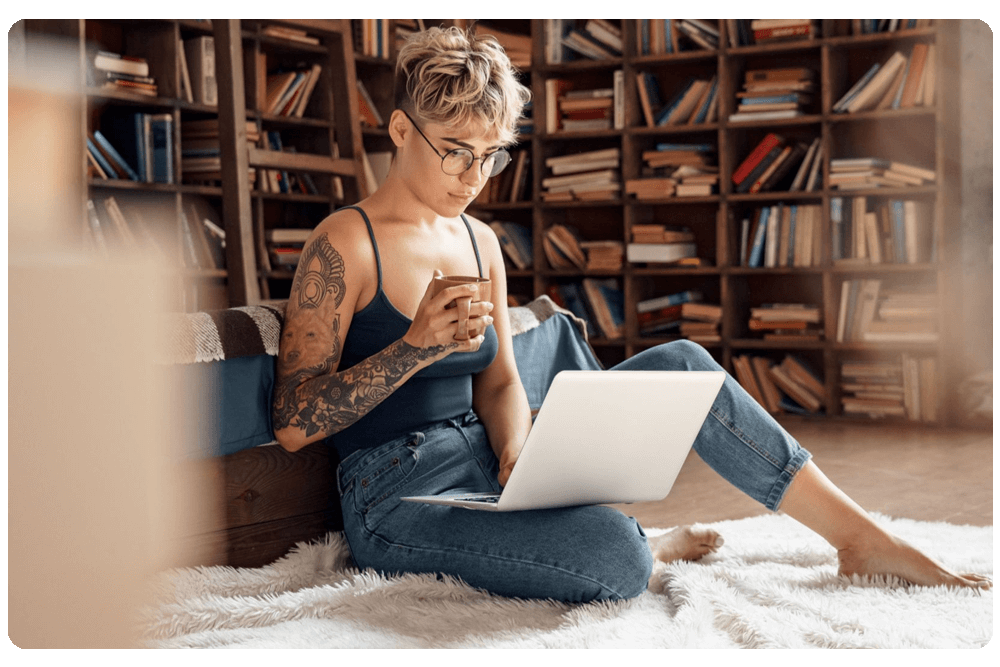 happy-woman-sitting-sofa-using-laptop-home-1-scaled-1